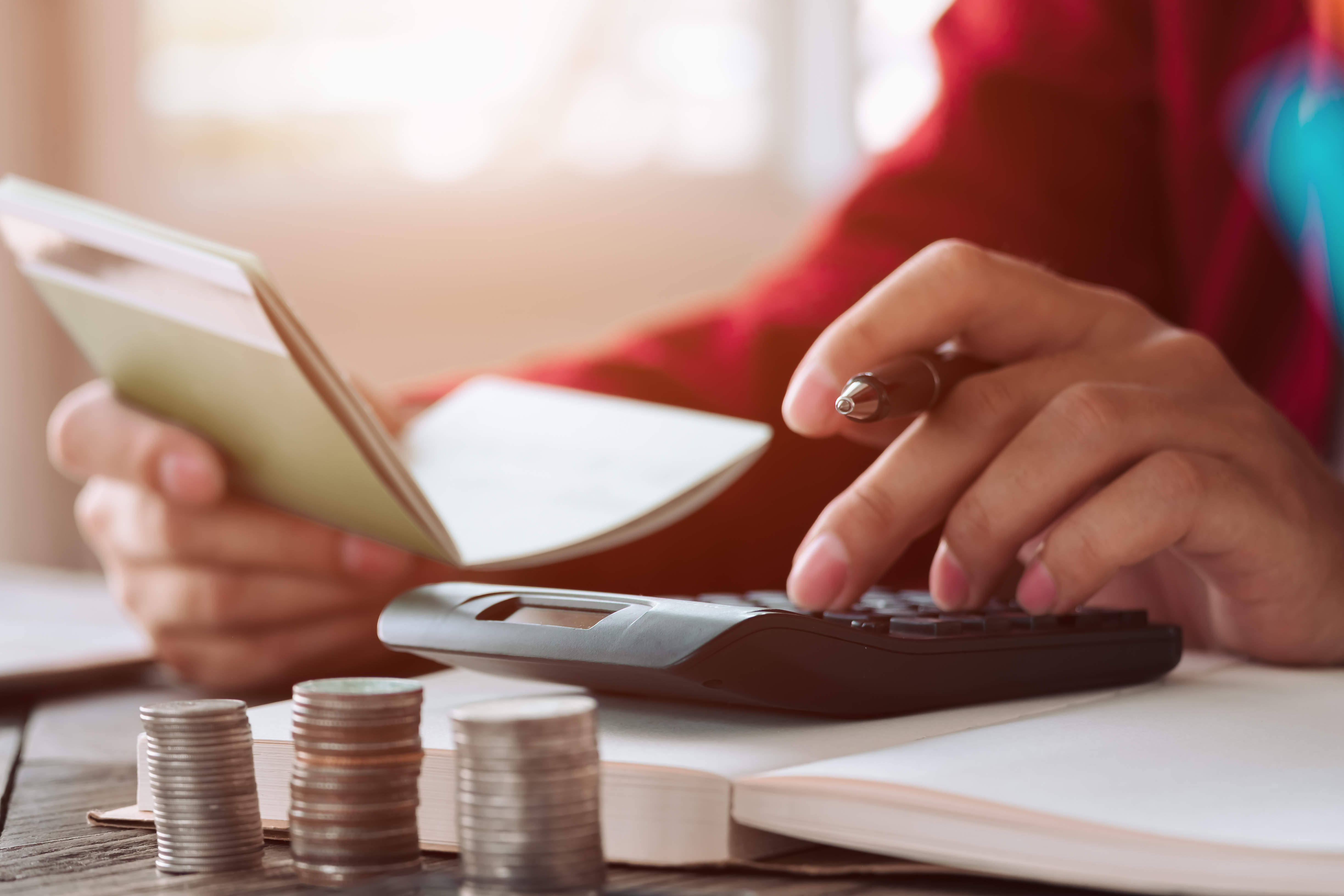 Shutterstock 1137051611 persona haciendo cuentas con una calculadora y una libreta